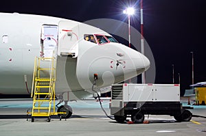 Plane parked at the airport at night, view nose cockpit.