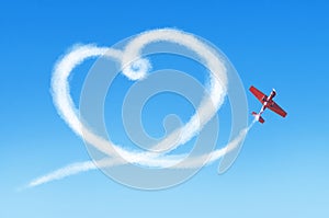 Plane in the sky draws a smoke heart