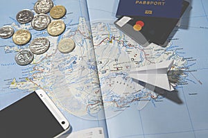 The plane, smartphone, biometric passport, dollars, coins and credit cards lie on a map