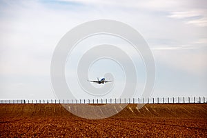 Plane takes off above a farmed field