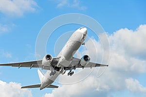 Plane takes off by retracting the landing gear against blue sky background