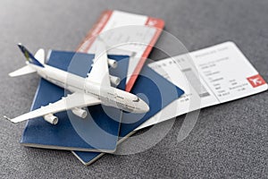 Plane tickets, passports and toy plane on table