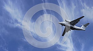 The plane took off into the sky. Airplane flight on a background of blue cloudy sky on a clear sunny day