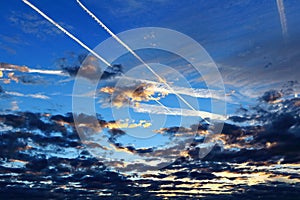 Plane contrails above clouds by blue hour photo