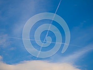 Plane trails in the shape of cross in blue sky