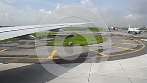 The plane turns on the runway, view from the window. Other planes at the airport are waiting for takeoff