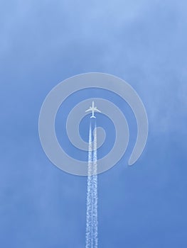 Plane with vapour trails in a blue sky