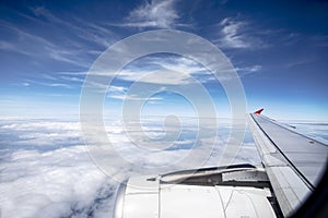 Through plane window with beautiful white cloud and blue sky