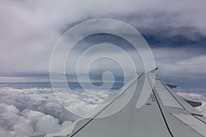 Plane wing on cloudy sky background