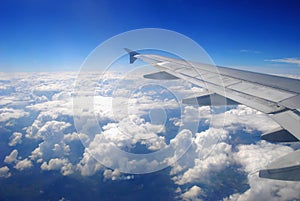 Plane wing flying above the clouds