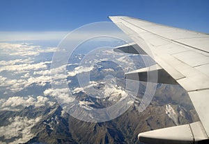 Plane wing over mountains