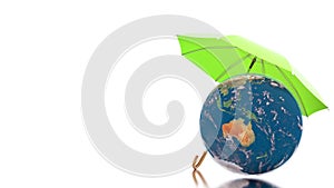 Planet care concept with rotating earth globe under protection of the green umbrella