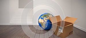 Composite image of planet earth and brown cardboard box