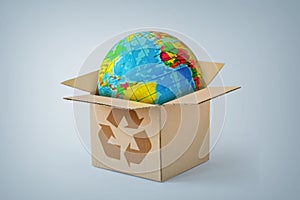 Planet earth in a cardboard box with recycling symbol - Concept of ecology and worldwide delivery