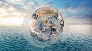 Planet Earth is floating over the ocean. Global warming, Travel Concept. (Elements of this image furnished by NASA