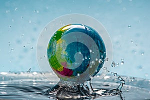 Planet Earth in the form of a globe in clear water with splashes. Concept of eco friendly behavior, keeping water clean