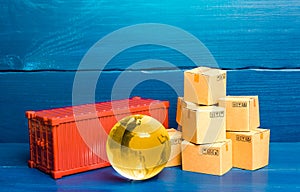 Planet Earth globe near a cargo container and boxes. World trade in goods. Economic ties. Production chains and product