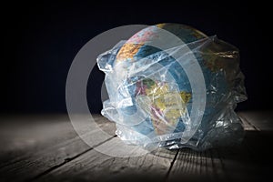 Planet Earth in polyethylene plastic disposable trash bag