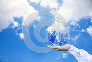 Planet and tree in human hands over blue sky with white clouds, Save the earth concept,