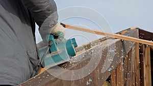 Planing a tree with an electric planer.