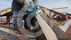 Planing a tree with an electric planer.