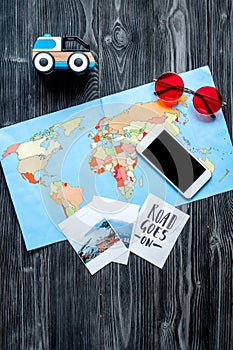 Planing trip with child with phone, pictures and map dark background top view space for text