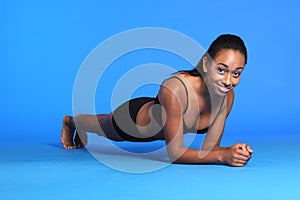 Plank ab exercise by happy African American woman