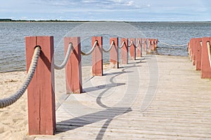 Plank footpath and fence boundary rope barrier on the beach