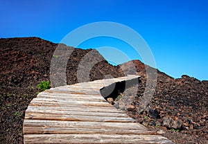 Plank way across volcanic black earth, near Punta de Teno, Island Tenerife, Canary Islands