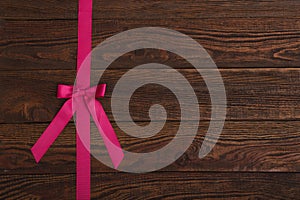 Plank wood texture background with pink ribbon