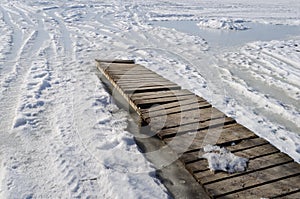 Planked footbridge at frozen pond