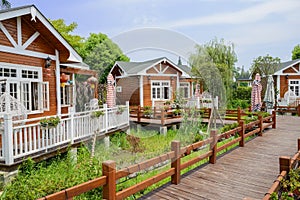 Planked path before wooden cabins in sunny summer