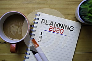 Planning 2020 write on the book with wooden table background