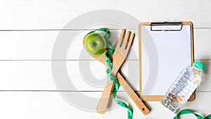 Planning for Diet Health eat and food.  Green Apple and measuring tape, note pad for fitness style.