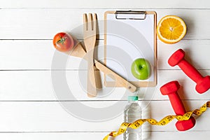 Planning for Diet Health eat and food.  Sport exercise equipment workout with fresh fruit, measuring tap, note pad for fitness sty