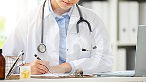 Planning, doctor writing on a clipboard and with laptop at a desk in a modern office with lens flare. Healthcare