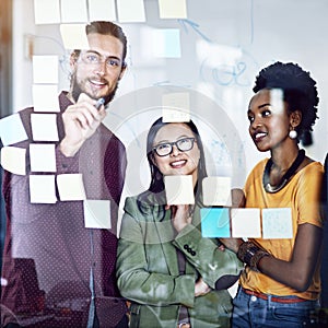 Planning for every circumstance. a group of businesspeople working on a glass wall the office.