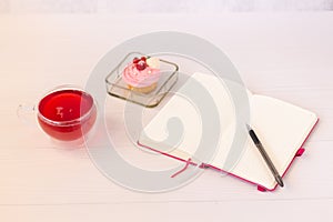 Planning laptop, high angle view of open blank notebook, cup and cupcake