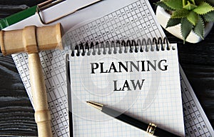 PLANNING LAW - words on a white sheet on the background of a judge\'s gavel, a cactus and a pen