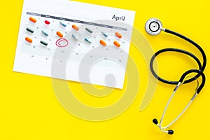 Planning medical examination concept. Regular medical examinations. Calendar with date circled, pills and stethoscope on