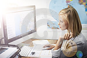 Planning perfect holidays for all of her clients. a young female travel agent working in her office.