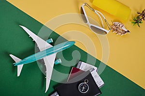 Planning, preparing for travel, vacation trip concept. Airplane with passports and tickets on a green background in front of beach