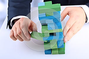 Planning, risk and strategy in business, businessman getting out a wooden block from a tower