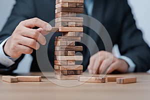 Planning, risk and strategy in business. Businessman holds the model of business, made from wood blocks. Alternative risk concept,