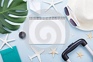 Planning summer holidays, vacations and trip. Travelers notebook with tourism accessories on blue table top view. Flat lay.