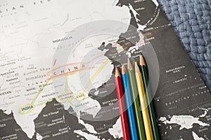 Planning travel with a colored pencil on a black / white map of Asia