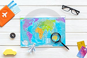 Planning a travel concept. Map of the world and tourist accessories on white wooden background top view