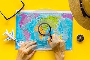 Planning a travel concept. Map of the world and tourist accessories on yellow background top view