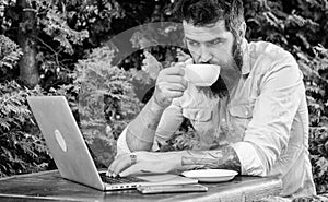 Planning vacation. Book apartment online. Man bearded hipster sit outdoors with laptop surfing internet and drinking