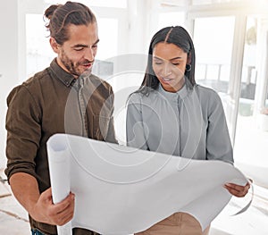 These plans look great. two young architects looking at building plans on site.